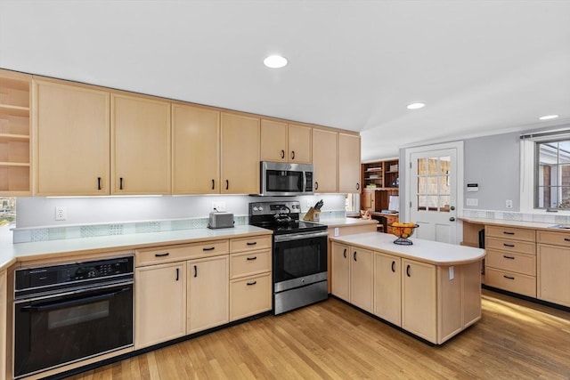 kitchen with stainless steel appliances, kitchen peninsula, light hardwood / wood-style floors, and light brown cabinets