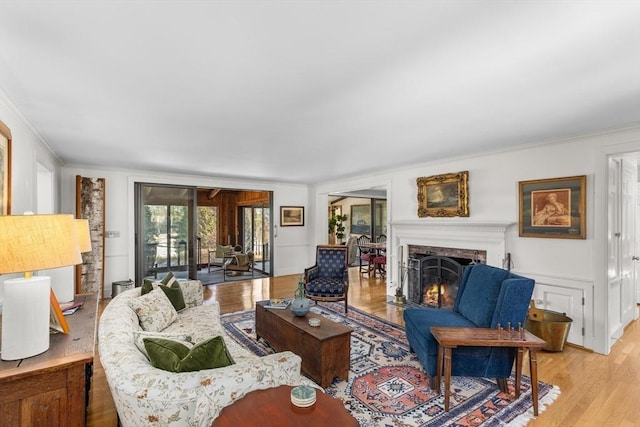 living room with ornamental molding and light hardwood / wood-style floors