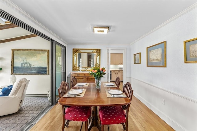 dining space featuring ornamental molding, light hardwood / wood-style floors, and a baseboard radiator