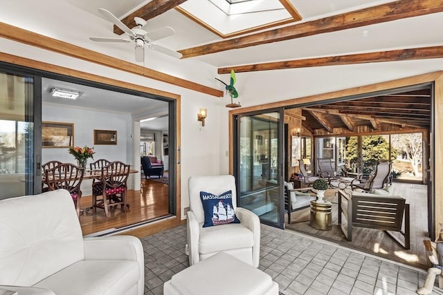 sunroom / solarium featuring plenty of natural light, vaulted ceiling with skylight, and ceiling fan