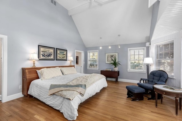 bedroom featuring multiple windows, beam ceiling, high vaulted ceiling, and light wood-type flooring