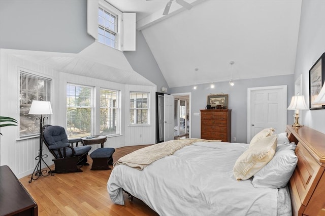 bedroom with beam ceiling, high vaulted ceiling, and light wood-type flooring