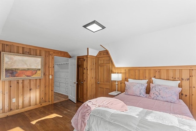 bedroom with wooden walls, dark hardwood / wood-style flooring, and vaulted ceiling