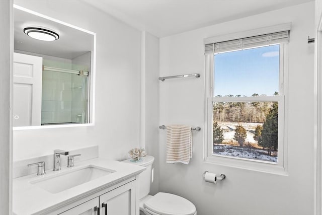 bathroom featuring vanity, toilet, and walk in shower