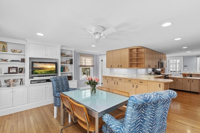 dining space with ceiling fan and light wood-type flooring