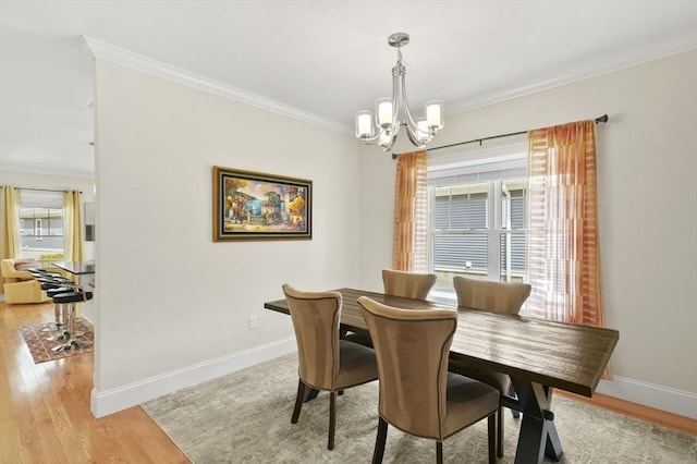 dining room with light wood-type flooring, baseboards, a chandelier, and crown molding