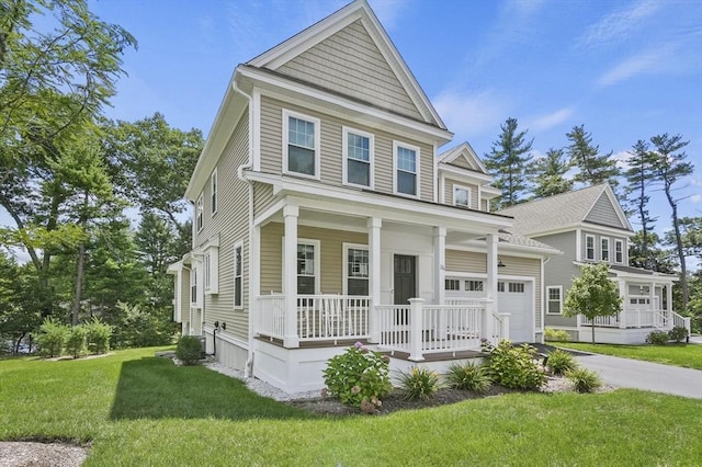 view of front of property with covered porch, driveway, a front yard, and a garage