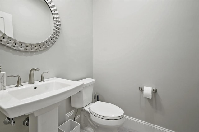 bathroom with baseboards and toilet