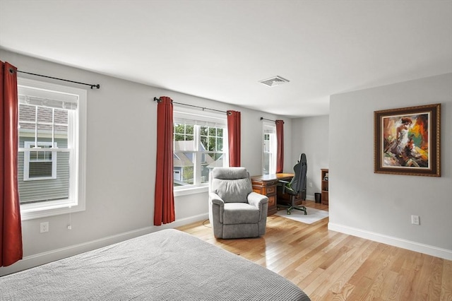 bedroom with light wood-type flooring, baseboards, and visible vents