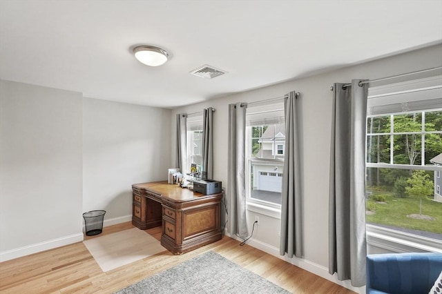 office area featuring light wood-type flooring, visible vents, and baseboards