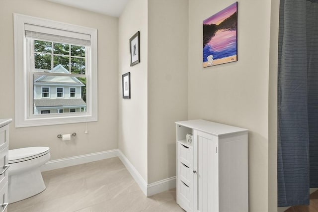 bathroom with vanity, toilet, and baseboards