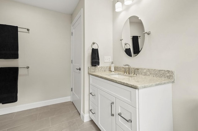 bathroom featuring tile patterned flooring, vanity, and baseboards