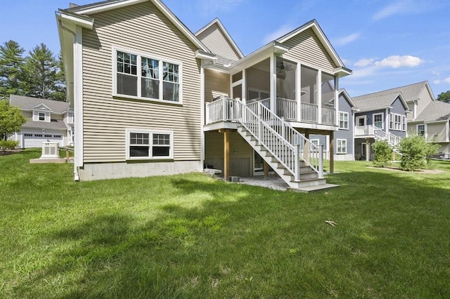 back of property featuring a sunroom, a lawn, and stairway