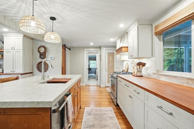 22 Partridge Rd, Duxbury, MA 02332 - kitchen with stainless steel range with gas cooktop, a sink, a barn door, light wood-type flooring, and custom range hood
