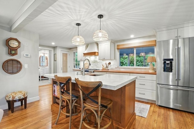 22 Partridge Rd, Duxbury, MA 02332 - kitchen with high quality fridge, premium range hood, light countertops, a kitchen island with sink, and light wood-style floors