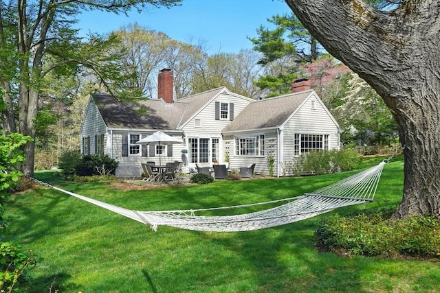 22 Partridge Rd, Duxbury, MA 02332 - rear view of house featuring a chimney, a lawn, a patio area, and a shingled roof