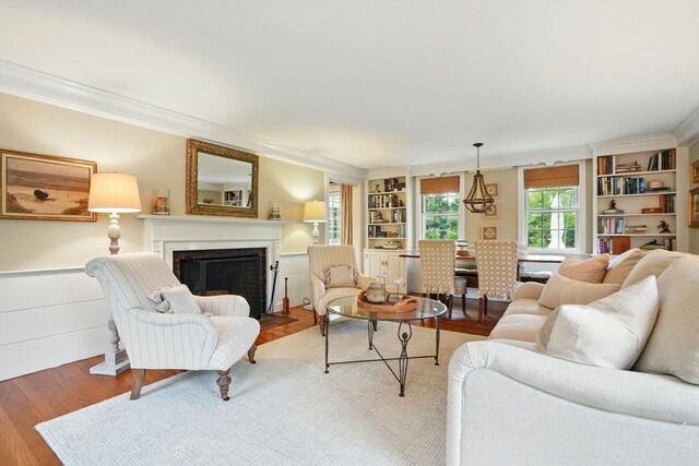 22 Partridge Rd, Duxbury, MA 02332 - living area with crown molding, wood finished floors, built in features, and a fireplace with flush hearth