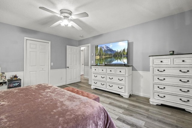 11 Broad St Unit 11, Hardwick, MA 01005 - bedroom with light wood-style floors, wainscoting, a textured ceiling, and a ceiling fan