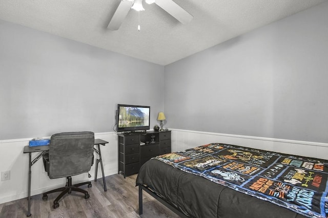 11 Broad St Unit 11, Hardwick, MA 01005 - bedroom featuring wood finished floors, wainscoting, a textured ceiling, and ceiling fan