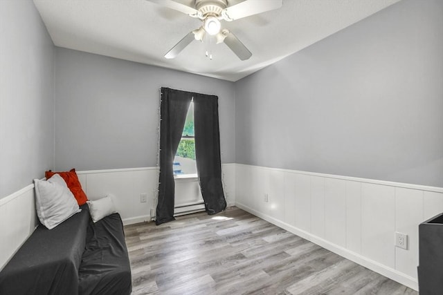 11 Broad St Unit 11, Hardwick, MA 01005 - sitting room with baseboard heating, a wainscoted wall, ceiling fan, and wood finished floors