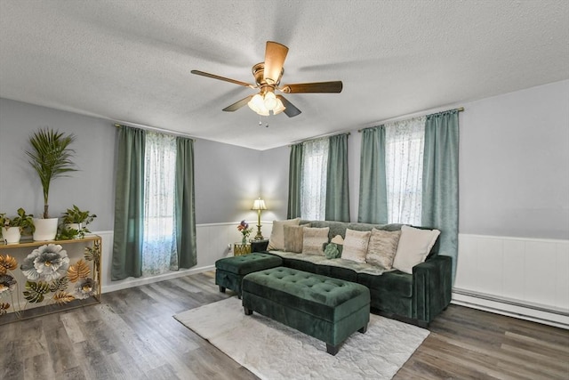 11 Broad St Unit 11, Hardwick, MA 01005 - living area with plenty of natural light, a textured ceiling, a wainscoted wall, wood finished floors, and a ceiling fan