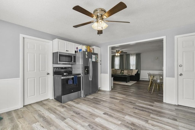 11 Broad St Unit 11, Hardwick, MA 01005 - kitchen with stainless steel appliances, a ceiling fan, light wood-style floors, white cabinets, and a textured ceiling