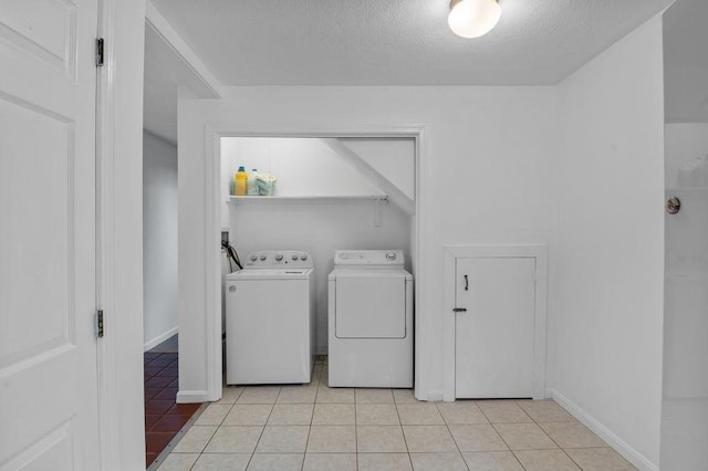 401 Colonial Dr Unit 35, Ipswich, MA 01938 - laundry area featuring washer and clothes dryer, a textured ceiling, light tile patterned floors, and baseboards
