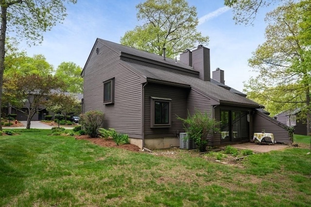 401 Colonial Dr Unit 35, Ipswich, MA 01938 - view of side of property with a lawn, a chimney, central air condition unit, and a shingled roof