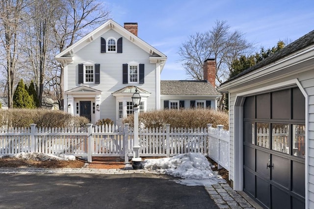 view of front of home featuring a fenced front yard and a chimney