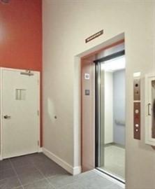 hallway featuring elevator and dark tile patterned floors