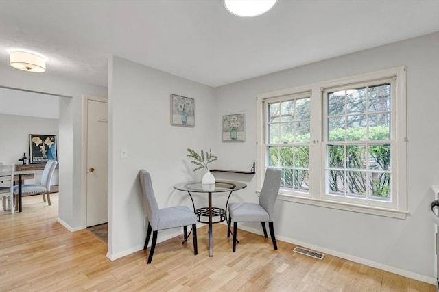 dining area with baseboards and light wood-style flooring
