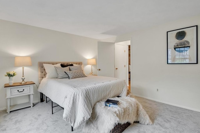 bedroom featuring light carpet and baseboards