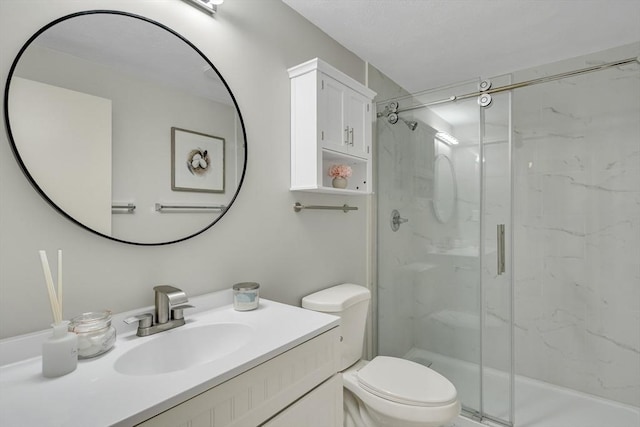 full bathroom featuring a marble finish shower, toilet, and vanity