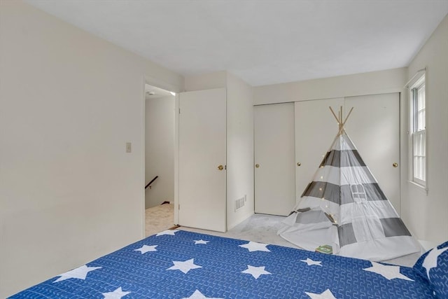 bedroom featuring light carpet and a closet