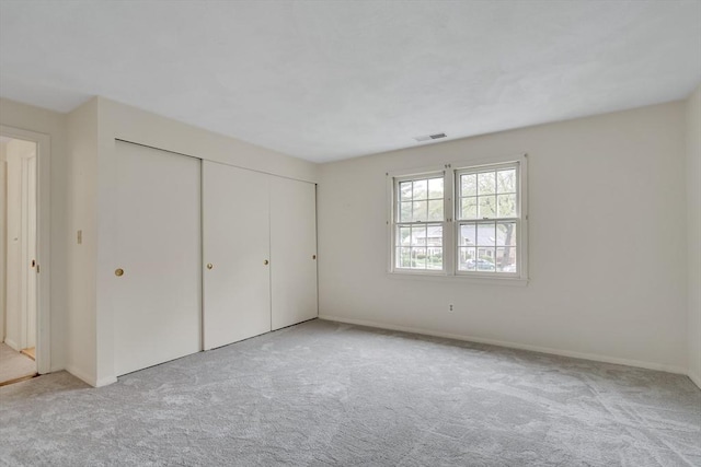 unfurnished bedroom featuring carpet flooring, a closet, and baseboards
