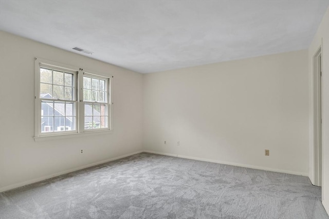 spare room featuring carpet floors and baseboards