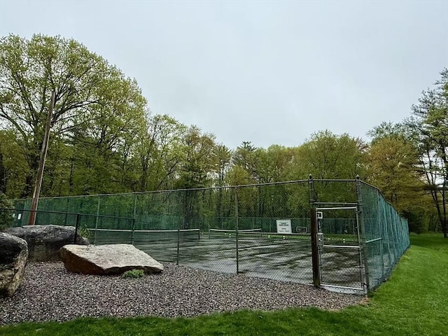 view of basketball court featuring a tennis court and fence