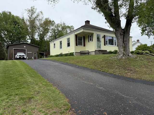 4 Perryville Rd, Webster, MA 01570 - view of front of house with a chimney, an outdoor structure, a garage, and a front lawn