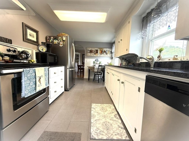 4 Perryville Rd, Webster, MA 01570 - kitchen with appliances with stainless steel finishes, white cabinets, light tile patterned floors, and arched walkways