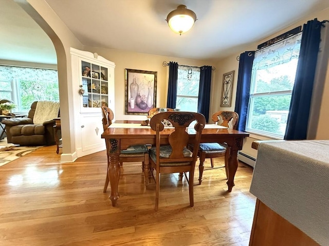 4 Perryville Rd, Webster, MA 01570 - dining space with a baseboard radiator, light wood-style flooring, and arched walkways