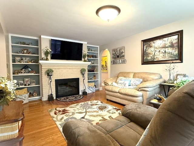 4 Perryville Rd, Webster, MA 01570 - living area with built in shelves, arched walkways, wood finished floors, and a fireplace