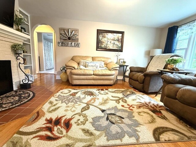 4 Perryville Rd, Webster, MA 01570 - living area featuring arched walkways, built in features, a fireplace, wood finished floors, and baseboards