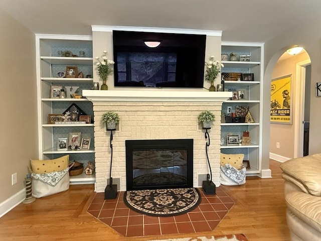 4 Perryville Rd, Webster, MA 01570 - living room with built in features, wood finished floors, baseboards, and a brick fireplace