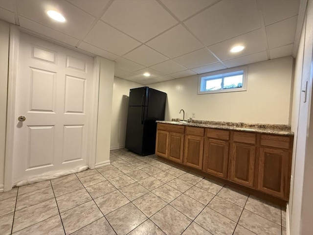 4 Perryville Rd, Webster, MA 01570 - kitchen featuring freestanding refrigerator, brown cabinetry, a paneled ceiling, light tile patterned floors, and a sink