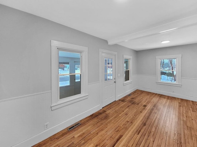 foyer featuring beamed ceiling and light hardwood / wood-style floors