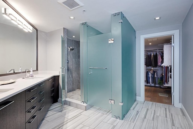 bathroom with vanity and a shower with door