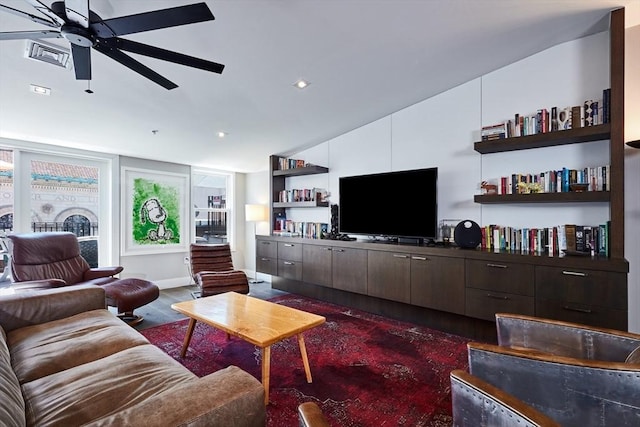 living room featuring dark wood-type flooring and ceiling fan