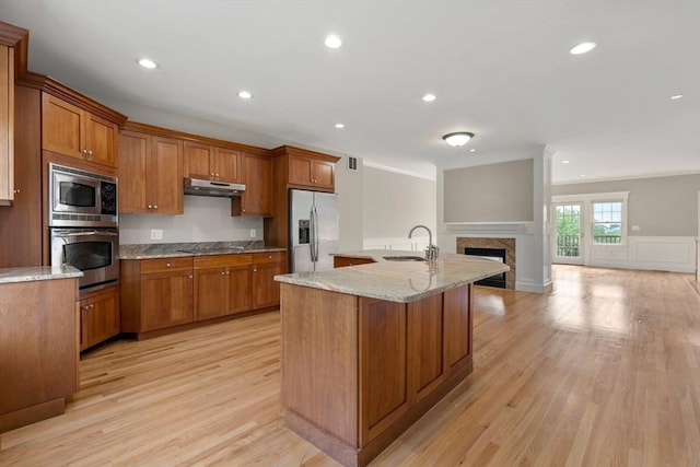 21 Musquashicut Ave Unit 27, Scituate, MA 02066 - kitchen featuring stainless steel appliances, a sink, under cabinet range hood, brown cabinets, and open floor plan
