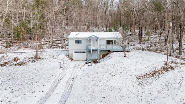 snow covered rear of property with a garage