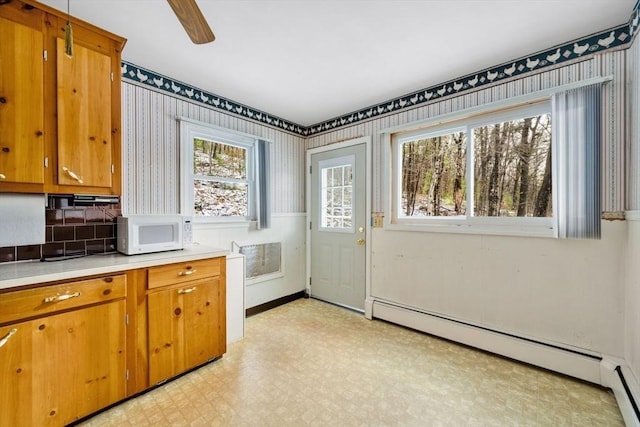 laundry room with ceiling fan and a baseboard radiator